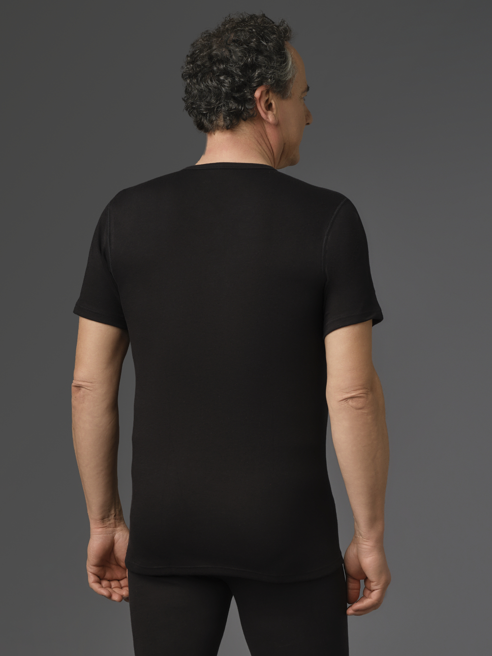 Short-sleeve V-neck shirt made from two-layer material by Comazo Protect in black color. Back view: Man wearing Short-sleeve V-neck shirt made from two-layer material by Comazo Protect in black color.