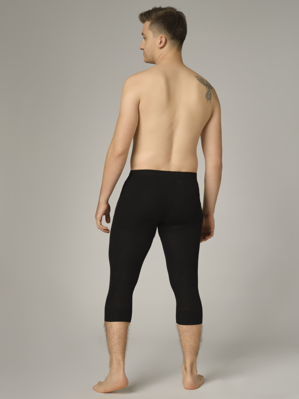 Comazo Unisex 3/4 Funktionshose "warm extra" Farbe Schwarz Rückansicht: Mann trägt 3/4 Unisex Funktionshose "warm extra" von Comazo in der Farbe Schwarz mit angerauter Innenseite zur optimalen Wärmespeicherung und schnelltrocknendem Funktionsmaterial dank sehr gutem Feuchtigkeitstransport