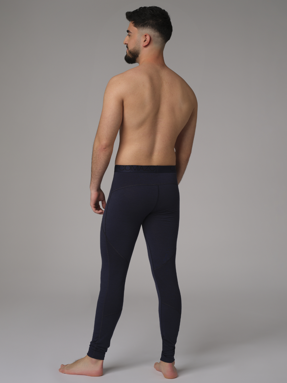 Comazo men's long underpants made of merino wool, color navy. Back view: Man wearing long underpants made of 100% mulesing-free merino wool by Comazo in navy color with Comazo logo waistband.
