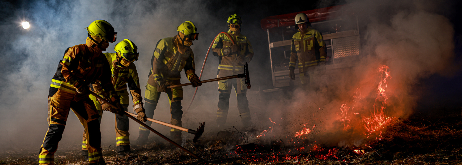 Feuerwehrmänner im Einsatz in gelber Uniform löschen einen Brand. Feuerwehrmänner im Einsatz in gelber Uniform löschen einen Brand.
