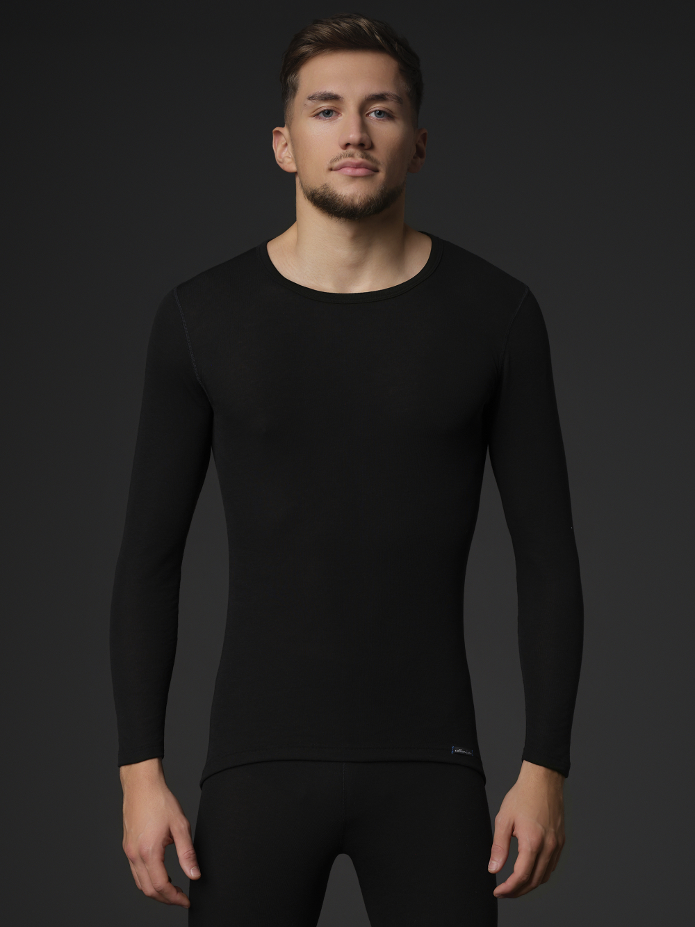 Comazo Unisex Funktionsshirt "warm extra" langarm Farbe Schwarz Vorderansicht: Mann trägt  Unisex Funktionsshirt "warm extra" langarm von Comazo in der Farbe Schwarz mit angerauter Innenseite zur optimalen Wärmespeicherung, Feuchtigkeitsmanagement und verlängertem Rückenteil