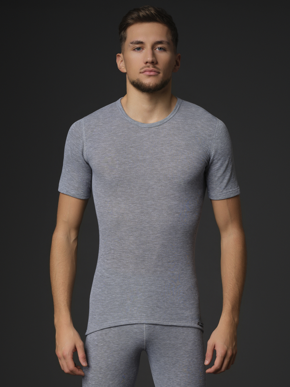 Comazo unisex short-sleeve functional shirt "warm extra", color gray melange. Front view: Man wearing unisex short-sleeve functional shirt "warm extra" by Comazo in gray melange, with a brushed inner lining for optimal heat retention, moisture management, and an extended back panel.