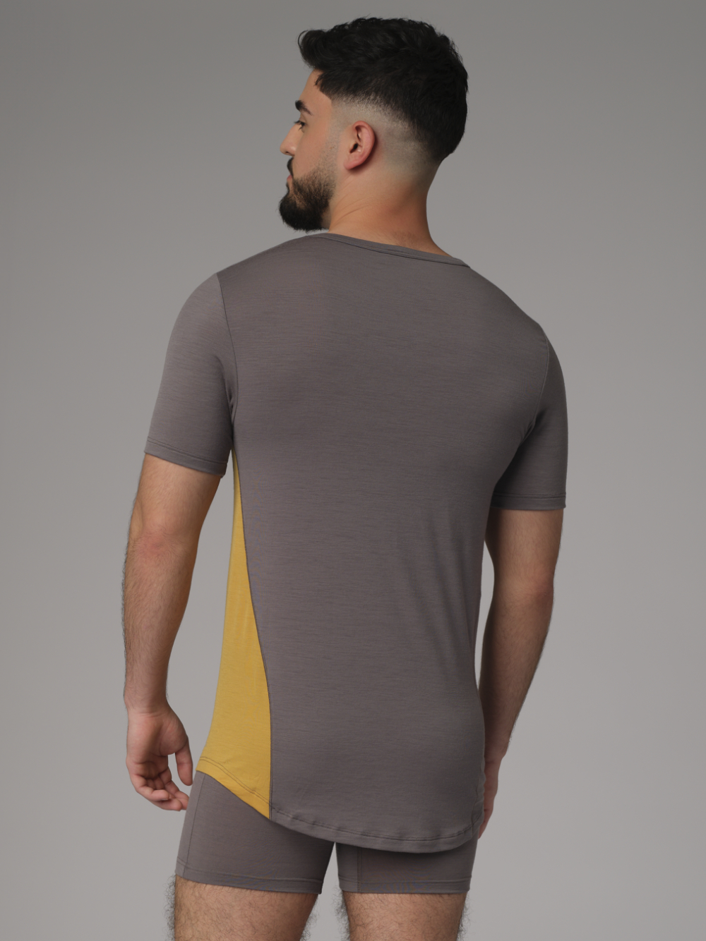 Comazo men's short-sleeve merino wool shirt in steel grey/mustard Back view: Man wearing a short-sleeve shirt made of merino wool from Comazo in the color Steelgrey/Mustard with a longer back and a round neckline.