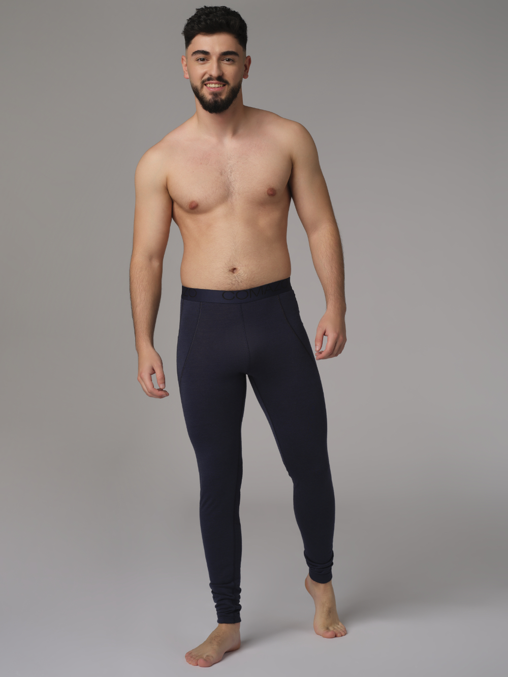 Comazo men's long underpants made of merino wool, color navy. Front view: Man wearing long underpants made of 100% mulesing-free merino wool by Comazo in navy color with Comazo logo waistband.