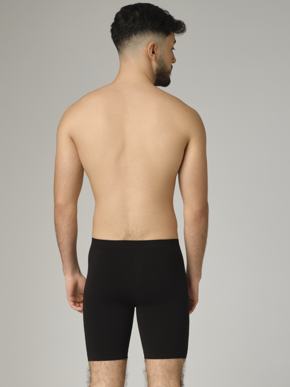 Comazo men's seamless pants with longer leg in the color black. Rear view: Man wearing seamless pants with longer leg by Comazo in the color black.