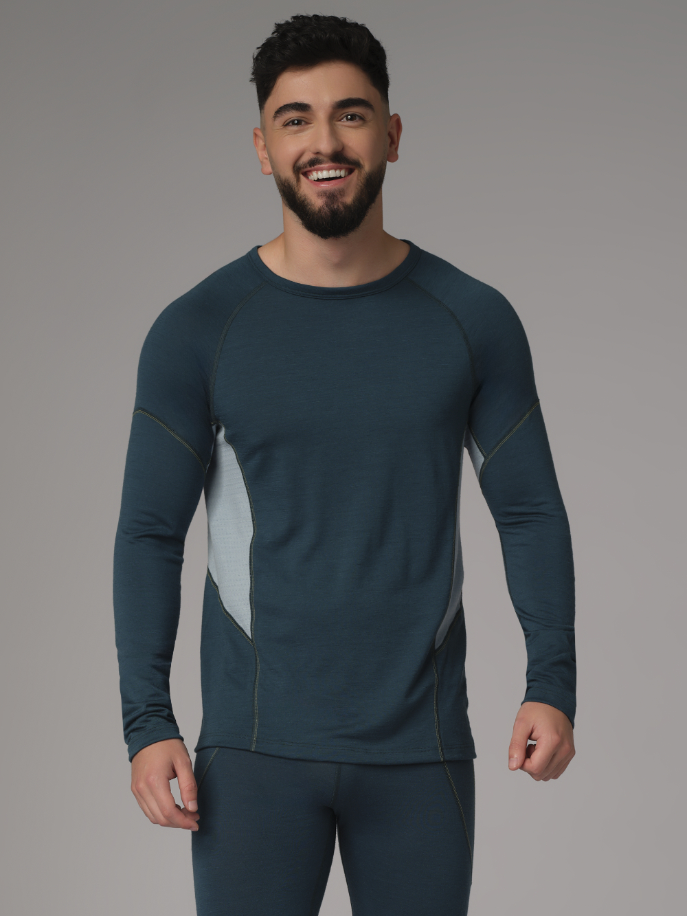 Comazo men's shirt long sleeve made of merino wool, color emerald/light green. Front view 2: Man wearing a long sleeve shirt made of 100% mulesing-free merino wool by Comazo in emerald/light green color with mesh inserts.