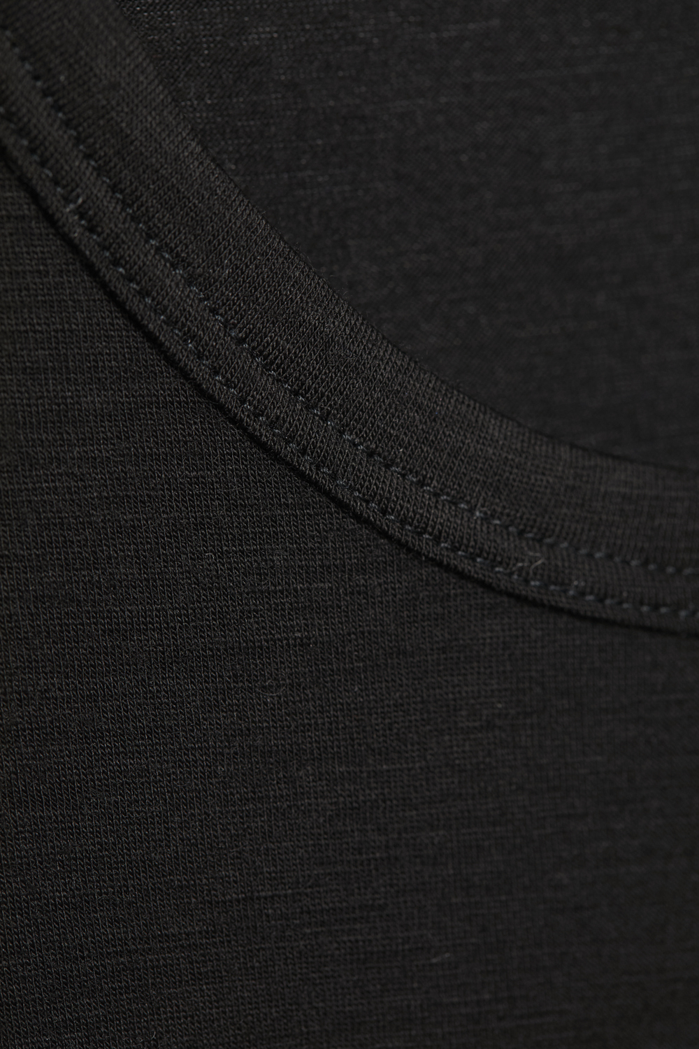 Comazo men's short-sleeve shirt made of merino wool, color black. Detail view: Short-sleeve shirt made of merino wool by Comazo in black color with extended back panel and crew neck.