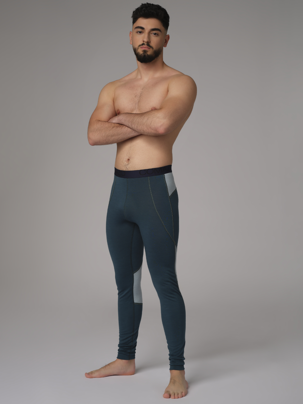 Comazo men's long underpants made of merino wool, color emerald/light green. Front view 2: Man wearing long underpants made of 100% mulesing-free merino wool by Comazo in emerald/light green color with Comazo logo waistband.