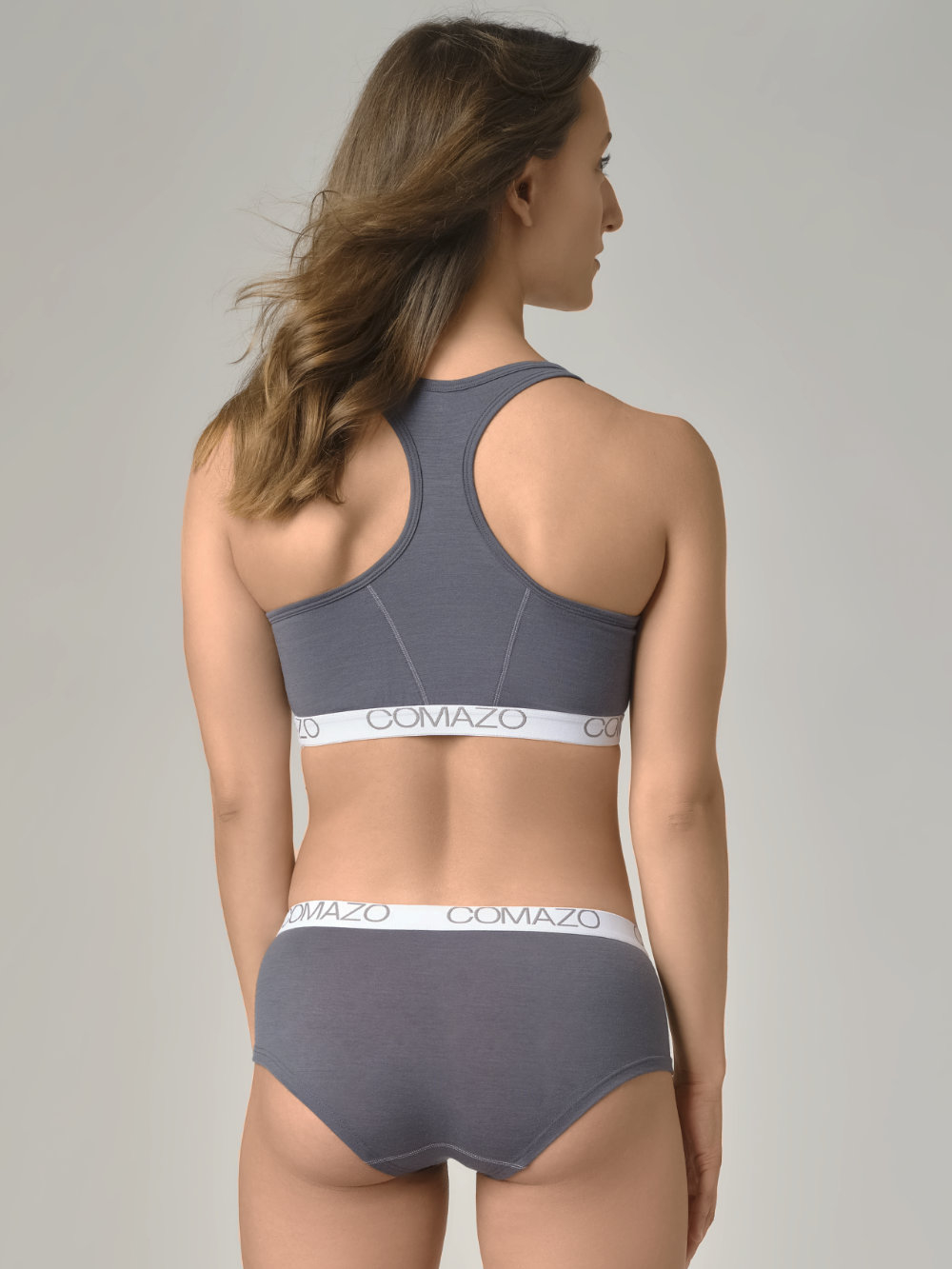 Rückansicht: Frau trägt  Bustier aus mulesing-free Merinowolle von Comazo in der Farbe Dunkelgrau