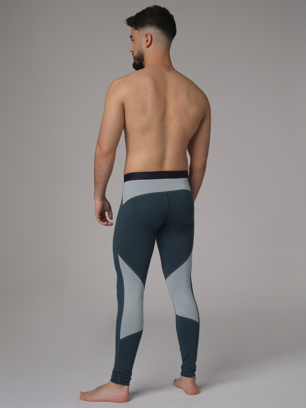 Comazo men's long underpants made of merino wool, color emerald/light green. Back view: Man wearing long underpants made of 100% mulesing-free merino wool by Comazo in emerald/light green color with Comazo logo waistband.