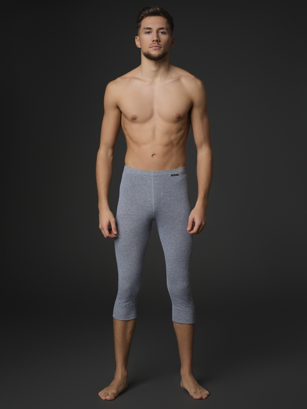 Comazo unisex 3/4 functional pants "warm extra", color gray melange. Front view: Man wearing unisex 3/4 functional pants "warm extra" by Comazo in gray melange, with a brushed inner lining for optimal heat retention and quick-drying functional fabric thanks to excellent moisture management.