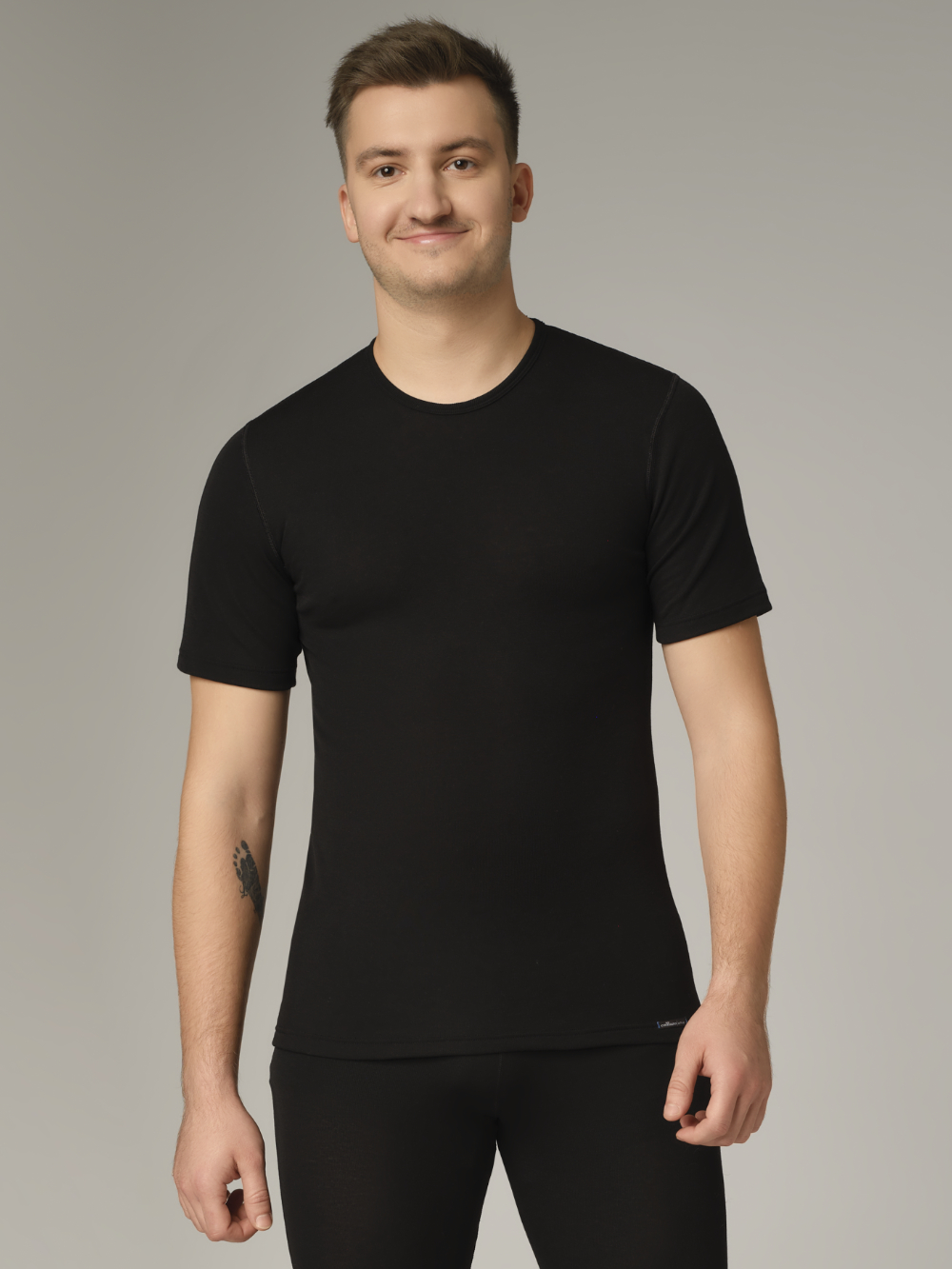 Comazo unisex short-sleeve functional shirt "warm extra", color black. Front view: Man wearing unisex short-sleeve functional shirt "warm extra" by Comazo in black, with a brushed inner lining for optimal heat retention, moisture management, and an extended back panel.