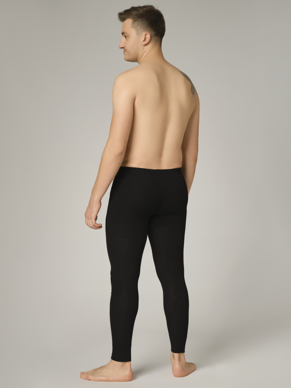 Comazo Unisex Funktionshose "warm extra" Farbe Schwarz Rückansicht: Mann trägt  Unisex Funktionshose "warm extra" lang von Comazo in der Farbe Schwarz mit angerauter Innenseite zur optimalen Wärmespeicherung und schnelltrocknendem Funktionsmaterial dank sehr gutem Feuchtigkeitstransport