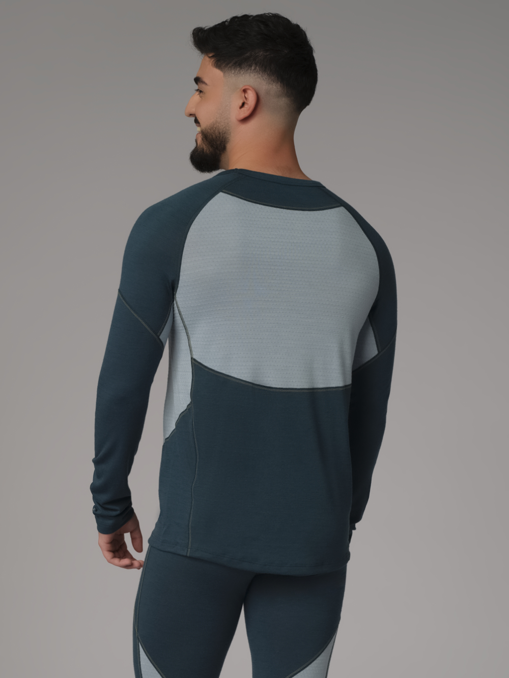 Comazo men's shirt long sleeve made of merino wool, color emerald/light green. Back view: Man wearing a long sleeve shirt made of 100% mulesing-free merino wool by Comazo in emerald/light green color with mesh inserts.