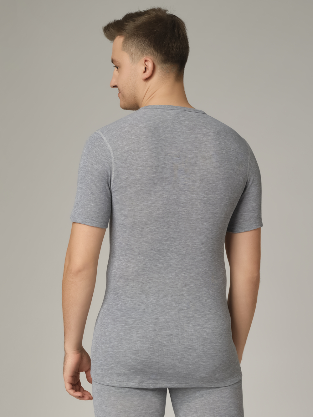 Comazo unisex short-sleeve functional shirt "warm extra", color gray melange. Rear view: Man wearing unisex short-sleeve functional shirt "warm extra" by Comazo in gray melange, with a brushed inner lining for optimal heat retention, moisture management, and an extended back panel.