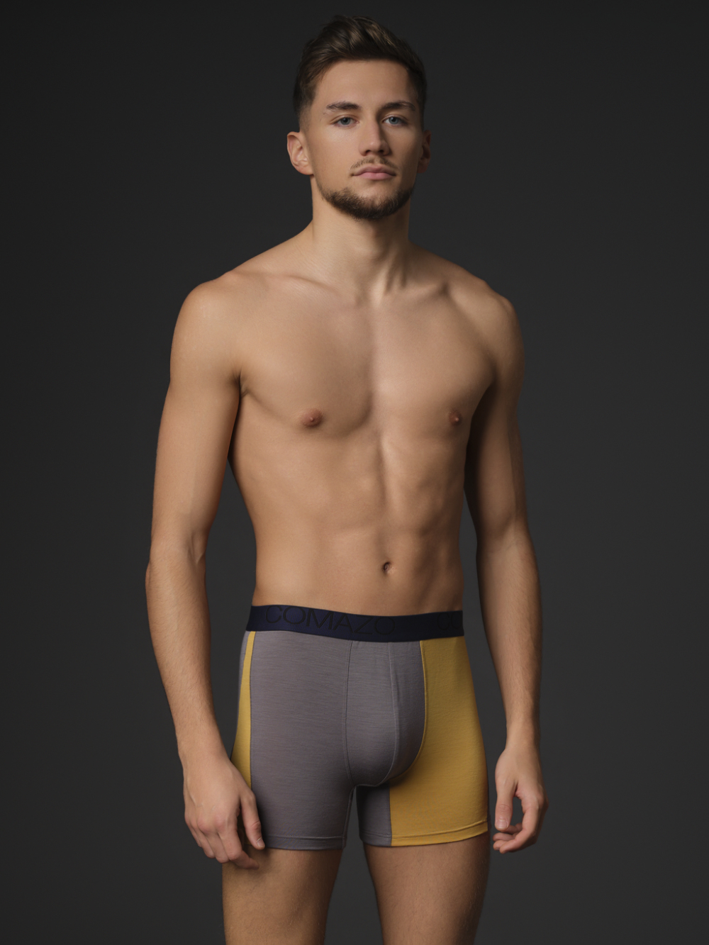 Comazo Herren Trunks aus Merinowolle Farbe Steelgrey/Senf Vorderansicht: Mann trägt Trunks aus Merinowolle von Comazo in der Farbe Steelgrey/Senf mit Schriftzug am Bund