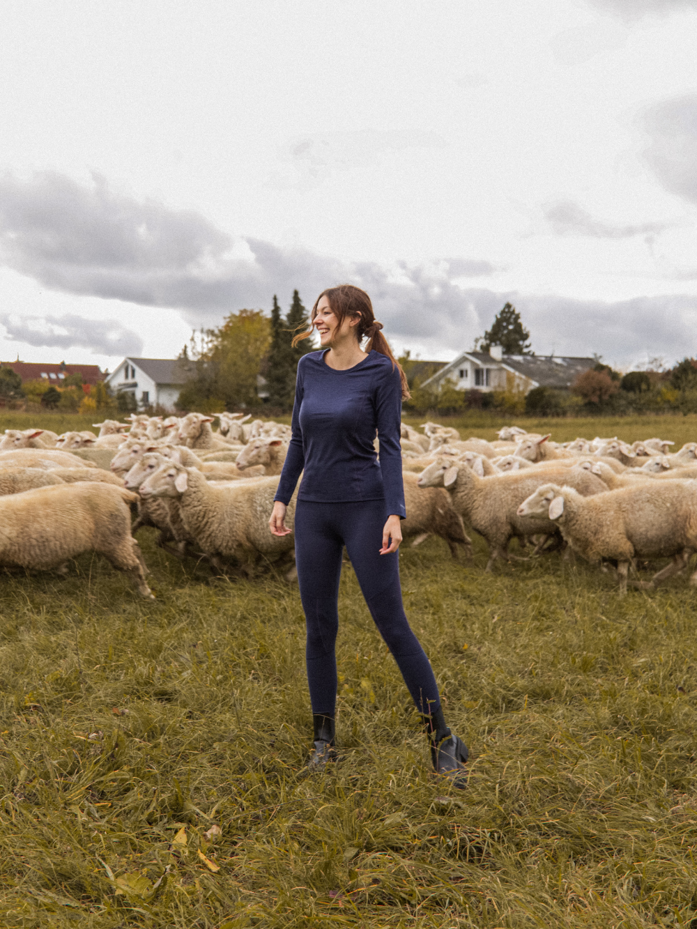 Vorderansicht in der Natur: Frau trägt Merinowolle-Shirt langarm von Comazo in der Farbe Navy aus 100% mulesing-freier Schurwolle mit Mesh-Einsätzen