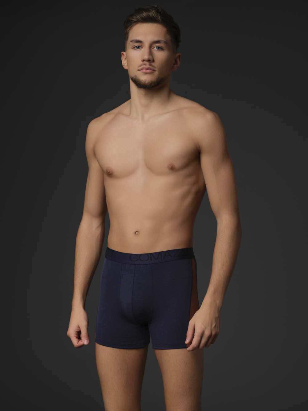 Comazo men's trunks made of merino wool in the color Navy/Chocolate. Front view: Man wearing Comazo merino wool trunks in the color Navy/Chocolate.