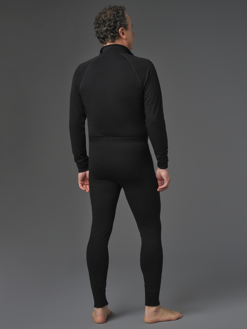 Merino wool functional pants (mulesing-free) by Comazo Protect in black color. Back view: Man wearing Merino wool functional pants (mulesing-free) by Comazo Protect in black color.