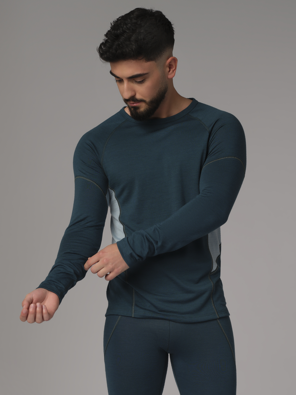 Comazo men's shirt long sleeve made of merino wool, color emerald/light green. Front view: Man wearing a long sleeve shirt made of 100% mulesing-free merino wool by Comazo in emerald/light green color with mesh inserts.