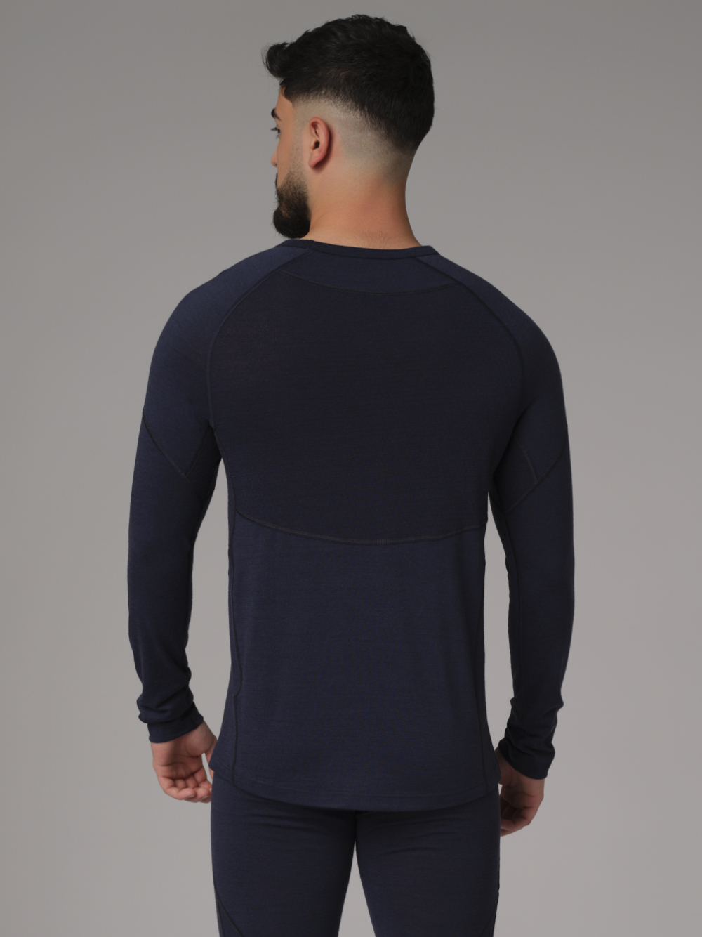 Comazo men's shirt long sleeve made of merino wool, color navy Back view: Man wearing a long sleeve shirt made of 100% mulesing-free merino wool by Comazo in navy color with mesh inserts.