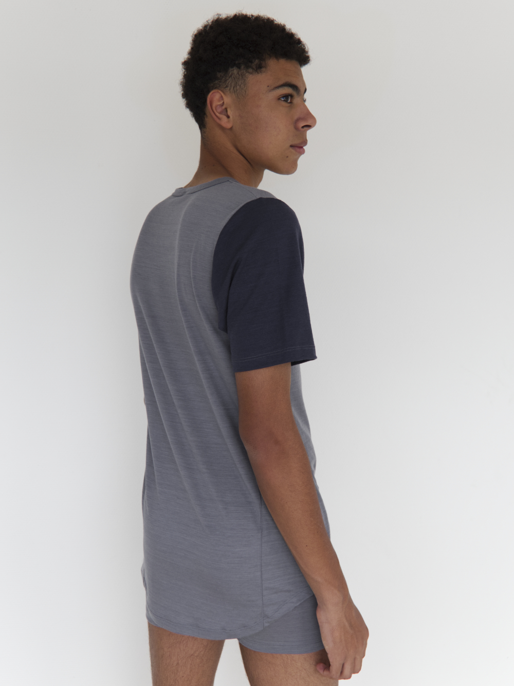 Comazo Herren Shirt kurzarm aus Merinowolle Farbe Grau/Navy Rückansicht 2: Mann trägt Shirt kurzarm aus Merinowolle von Comazo in der Farbe Gray/Navy mit längerem Rückenteil und Rundhalsausschnitt