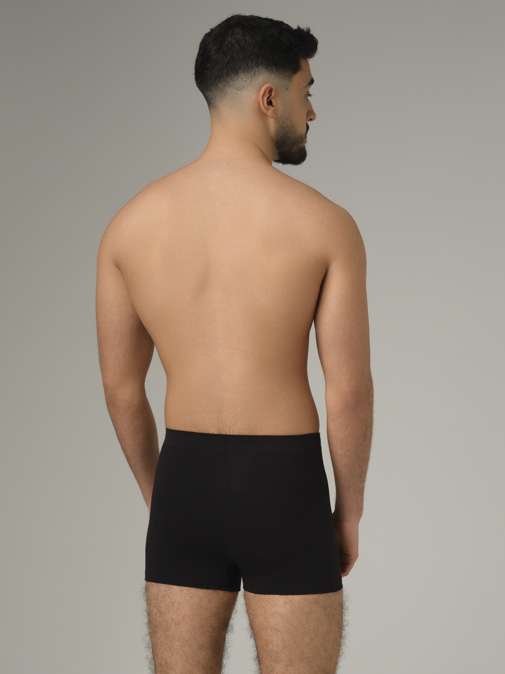 Comazo men's seamless trunk in black color. Rear view: man wearing seamless trunks by Comazo in the color black.