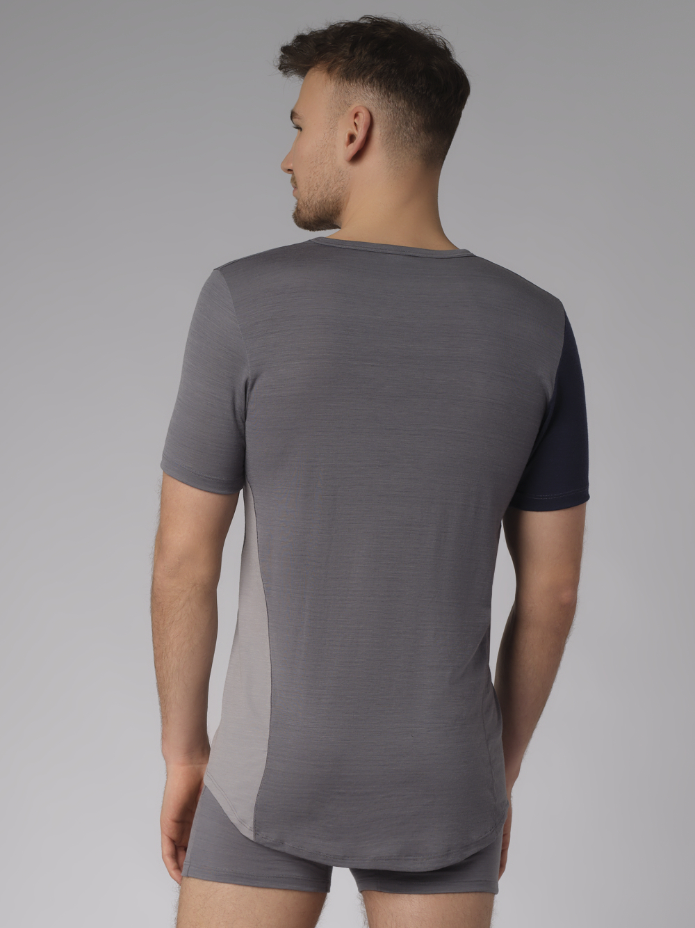 Comazo Herren Shirt kurzarm aus Merinowolle Farbe Grau/Navy Rückansicht: Mann trägt Shirt kurzarm aus Merinowolle von Comazo in der Farbe Gray/Navy mit längerem Rückenteil und Rundhalsausschnitt